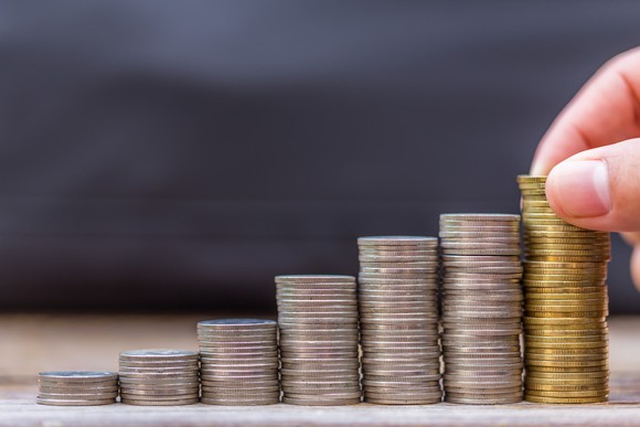 Hand stacking coins in successively larger piles to create graph.