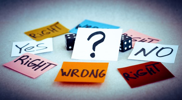 A pair of dice surrounded by slips of paper reading "right," "wrong," "yes," and "no," and one slip showing a question mark.